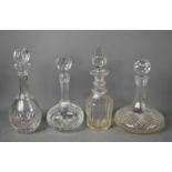 A group of four cut glass decanters, including a Victorian example.