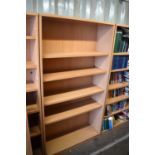 A set of eight pine effect bookcases with extra shelves.