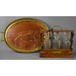 A Victorian oak cased tantalus, with three cut glass decanters, the case clad with brass and
