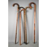 A group of five vintage walking sticks of various form, two knotwood examples, one in bamboo with