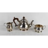 A silver tea set, comprising tea pot, 13.9cm sugar bowl 4.4toz, and milk jug 3.2toz, Birmingham