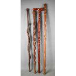A group of four vintage walking canes, one carved with a wrythen snake, one of twist form and one