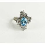 An 18ct white gold, diamond and topaz dress ring, the central oval cut Topaz of approximately 6 by