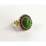 A 19th century dress ring, set with oval green stone cabochon, 14.5 by 12mm, surrounded by twenty