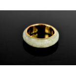 A 14ct gold and jade Chinese ring, with pierced symbols to the inside of the band, and carving to