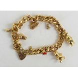 A 9ct gold curb link charm bracelet with heart shaped padlock clasp and safety chain, with four