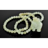 A pale jade bead necklace, with elephant pendant, the necklace being approximately 76cm long,