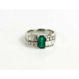 A 14ct white gold, emerald and diamond Art Deco style dress ring, the central emerald of