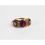 A 19th century gold (unmarked) and paste ring, the three oval cut pink stones of differing shades,