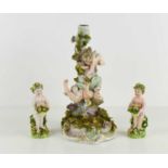 A German porcelain candlestick modelled with cherubs amongst a rose bush, 24cm high, and a pair of