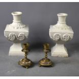 A pair of painted cast iron candle sticks of large form together with a pair of brass candlesticks.