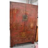 A large 19th century Chinese red lacquered wedding cabinet with gilt painted decoration of village