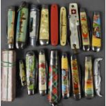 A group of vintage souvenir folding pocket knives, including a white metal example from the 1900