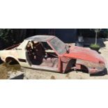 A Fiat X/19 body shell with a large amount of spares, the car has had a lot of the body work