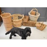 A large group of wicker baskets including a tall stick basket, a laundry hamper, a large oval