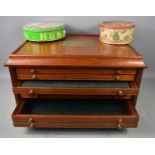 A mahogany coin collectors cabinet of seven drawers, with brass plaque to the top, 'The 100 Greatest