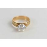 A 14k gold solitaire ring, set with iridescent brilliant cut stone.