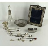 A group of silver and silver plated items to include silver sugar tongs, silver and amber pickle