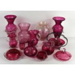 A group of 19th and 20th century cranberry glass wares, including jugs, vases and a trinket dish and