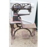 A vintage Singer 29K4 leather sewing machine on a cast iron treadle base.