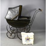 A Victorian doll's pram, in black livery with original canework base an seats and reversable leather