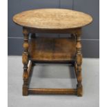 A 19th century oak table with circular top, and square undertier, united by turned legs and