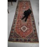 A Middle Eastern blue ground wool runner, with geometric stylised motifs in various colours, 90 by
