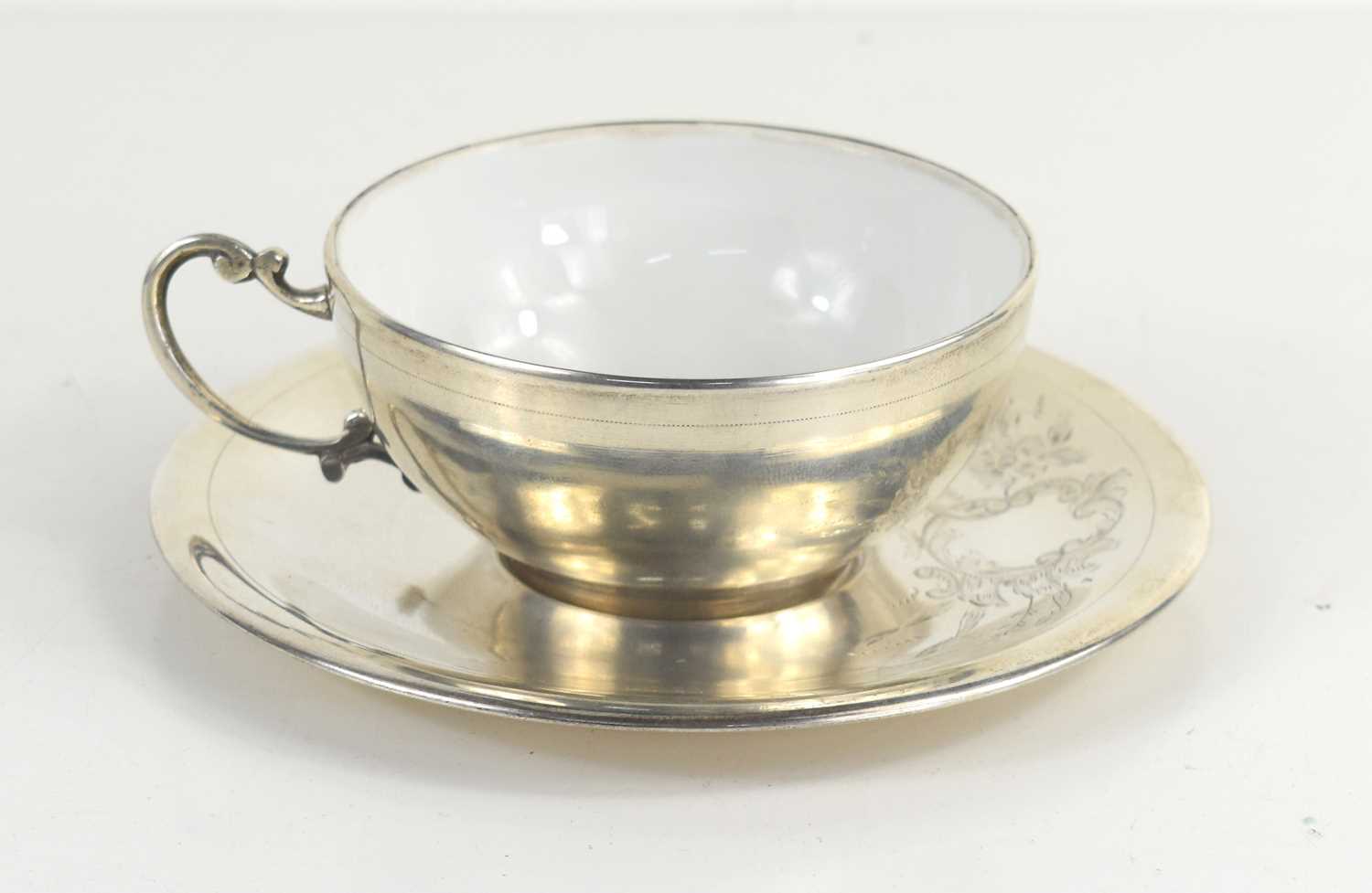 An Egyptian silver cup and saucer, the porcelain cup overlaid with silver and hallmarked with