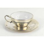 An Egyptian silver cup and saucer, the porcelain cup overlaid with silver and hallmarked with
