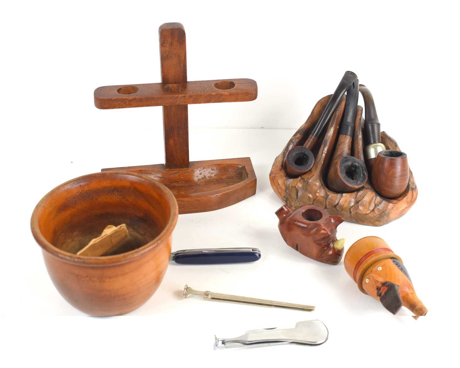 A group of smoking pipes to include an example by Petersons, together with two pipe racks, tampers