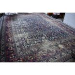 A large middle eastern carpet, with borders of stylised flowers and foliage, 13ft by 18ft. [