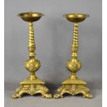 A pair of brass pricket candlesticks with circular drip pan and spike, supported on a twisted stem