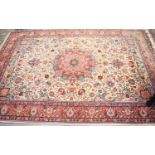 A high quality Kashan rug, the densely knotted cream ground with abundant floral motifs, with red