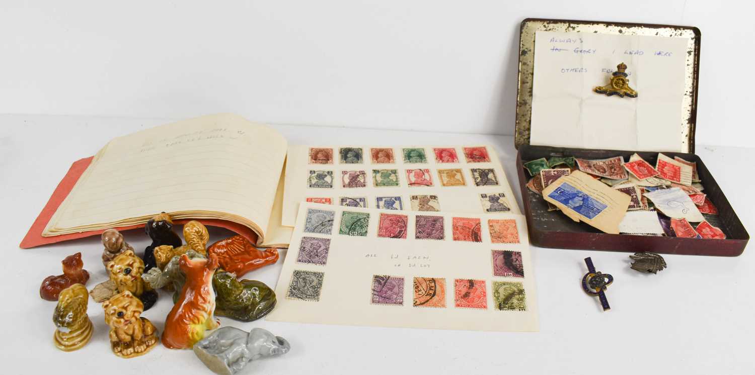 An album of stamps including Edwardian examples, loose stamps, military badges and Wade Whimsies.