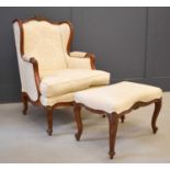 A late 19th century wing back armchair, with matching stool, the carved mahogany frame upholstered