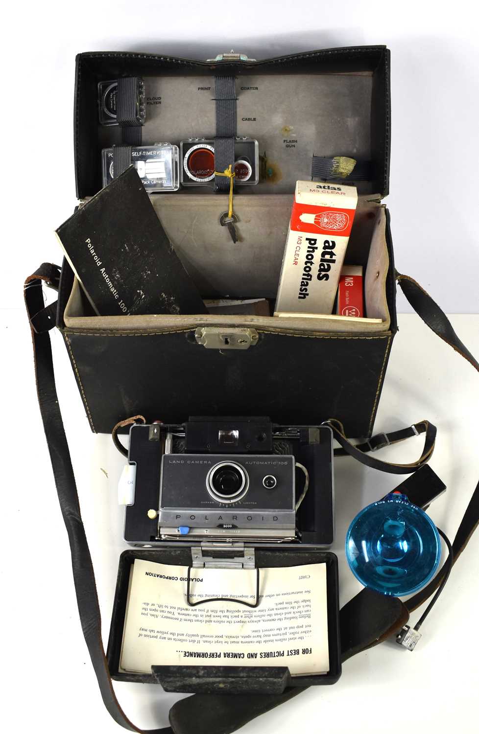 A vintage Polaroid Automatic 100 Land Camera in its original fitted case with accessories to include