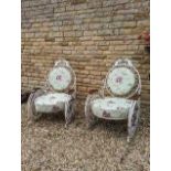 A pair of fin-de-siecle cast iron garden chairs, with wrought iron roses, the frame painted cream