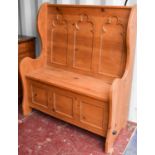 A pine box seat settle with Gothic style carved back, 113cms tall by 96cms long by 47cms deep