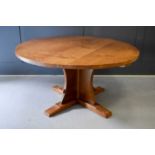 A Robert Thompson Mouseman oak dining table of circular form, the adzed top riased on a cruciform