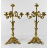 A pair of early 20th century gilt brass four branch candelabra, with foliate scrolling branches,