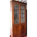 An unusual 19th century mahogany corner cupboard, the astrigal glazed doors enclosing a shaped