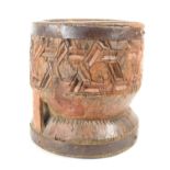 An African carved hardwood mortar with iron work banding, 29.5cm high.