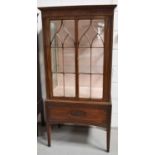 A 20th century mahogany display cabinet, enclosing a glass shelved interior, above a carved apron