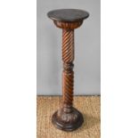 A late 19th century mahogany torchere, spiral carved column and foliate carved collars and knop,