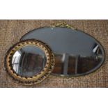 An early 20th century brass framed oval mirror together with a smaller circular mirror.