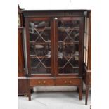 A mahogany glazed cabinet, with two glass doors enclosing shelved interior, with two drawers