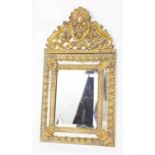 A Venetian embossed brass wall mirror, with bevelled glass panels bordered by decorative foliate