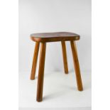 A Robert Mouseman Thompson stool, standing on four faceted tapering legs, with oak adzed seat,