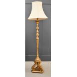 A giltwood standard lamp with a fluted and leaf-collared stem to form a tripod base, 180cm high.