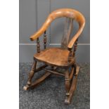 A 19th century childs rocking chair with shaped back and spindle support. The joints on the curved